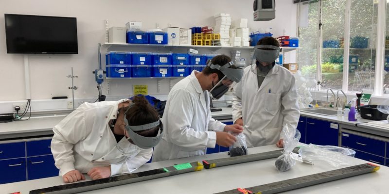 Three people working in a lab sampling core material